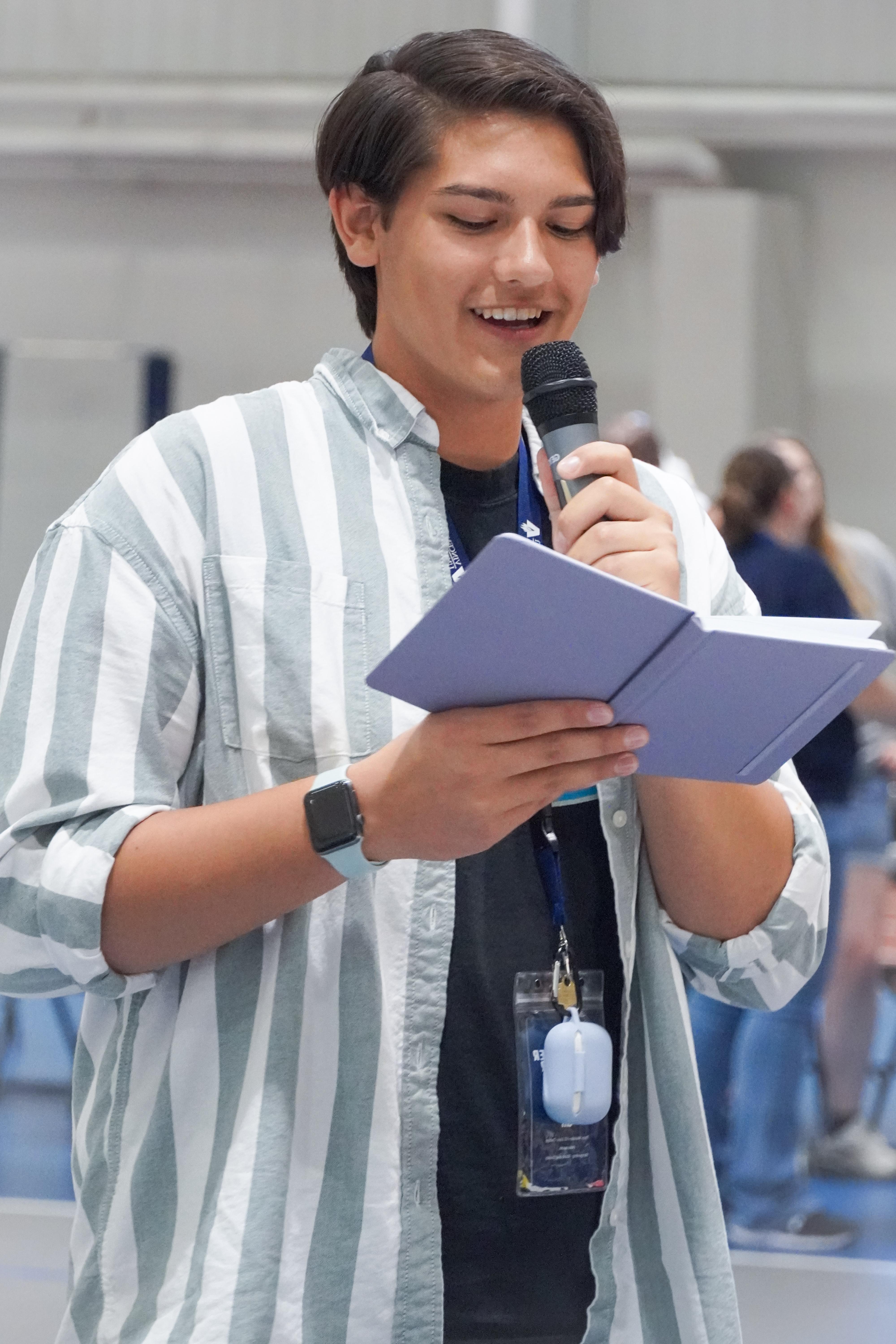 Young latino man speaking at a microphone